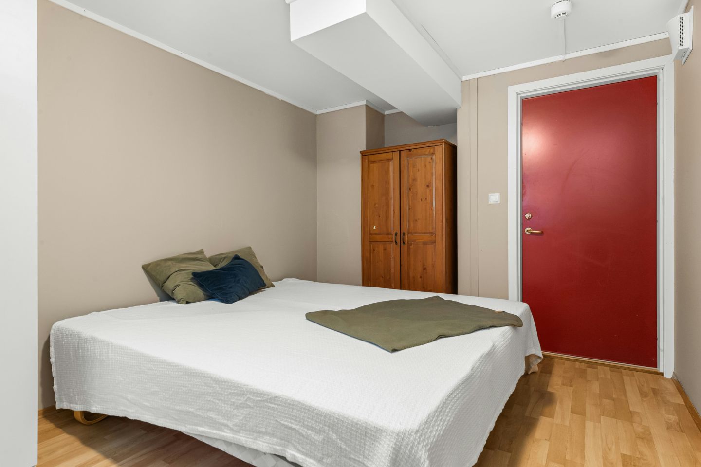 A bed sitting in a bedroom next to a red door